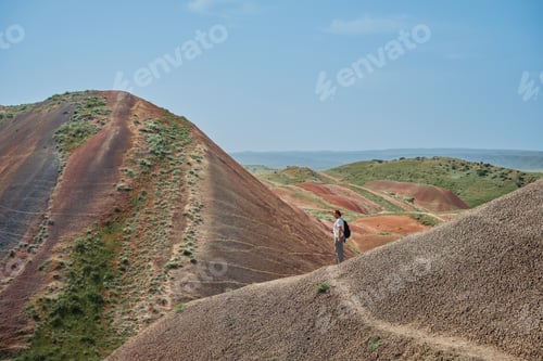 Preview: Portrait of a young man on a hiking route through the beautiful red mountains
