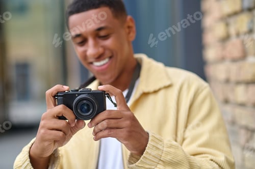 Preview: Positive photographer with camera in hands looking happy