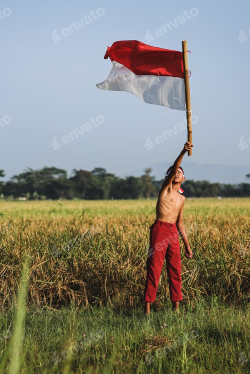 Preview: Boy celebrating Indonesian Independence Day by waving a flag