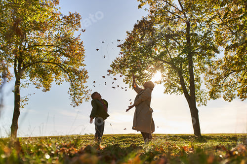 Preview: silhouette of mother and child throwing autumn leaves, park, fall season, having fun, freedom