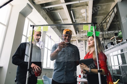 Preview: Three multiethnical businesspeople in casual wear discussing and planning concept, working together
