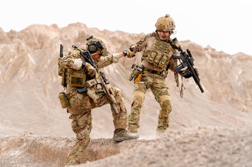 Preview: One soilder or military man pull his friend up from slope in area near the mountain