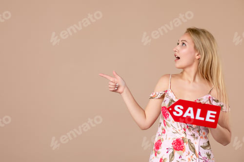 Preview: front view young female holding red sale nameplate on brown background money march horizontal