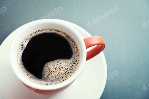 Preview: Red cup of coffee and white saucer