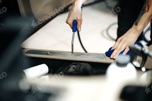 Preview: Woman cleaning car salon with polishing spray in car detailing service