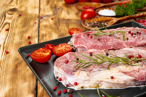 Preview: Two raw beef steaks on dark wooden table
