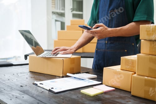 Preview: A man is working at his desk, preparing parcel boxes for shipment. He checks packs items carefully