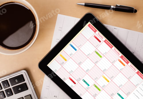 Preview: Workplace With Tablet Pc Showing Calendar And A Cup Of Coffee On A Wooden Work Table Close-Up