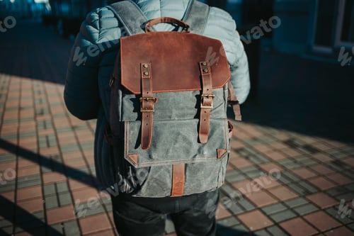 Preview: Shallow focus shot of a male wearing a grey and brown rucksack