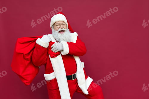 Preview: Happy Santa Claus holding sack with Christmas gifts walking on red background.
