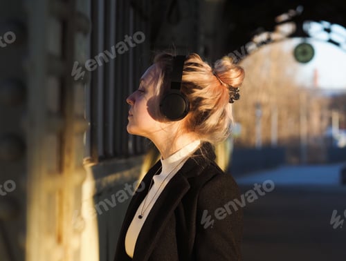 Preview: Woman with Headphones Outdoors Enjoying Peaceful Moment