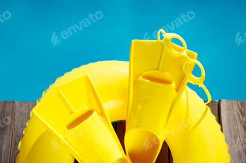 Preview: Fippers and goggles on wooden planks near swimming pool