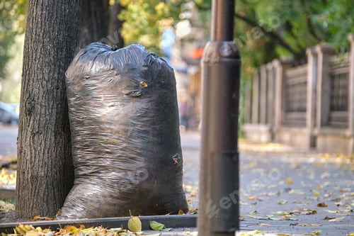Preview: Pile of black garbage bags full of litter left for pick up on street side. Trash disposal concept