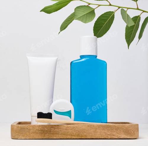 Preview: Refreshing mouthwash in a transparent plastic bottle and dental floss on a blue background