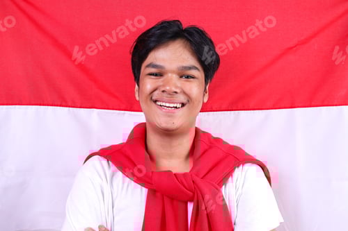 Preview: Smiling Young Man Posing in Front of Flag