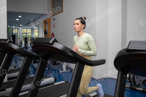 Preview: Woman running on treadmill at gym maintaining healthy lifestyle