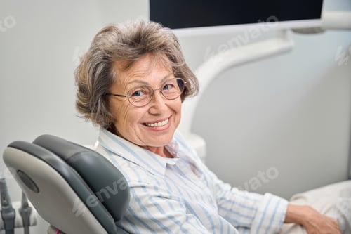 Preview: Gray-haired elderly woman sits in a dentists chair