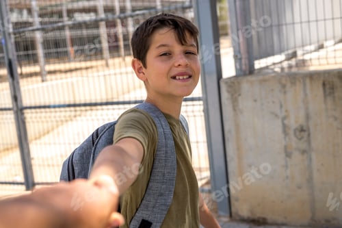 Preview: Cheerful child carrying his backpack standing in front of the sc
