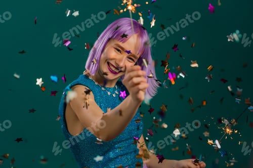 Preview: Hipster woman with sparkling bengal fire dancing under confetti rain on green background. Christmas