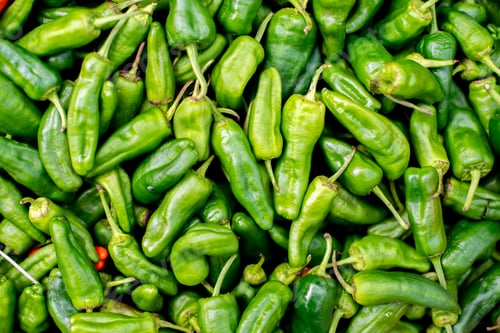 Preview: closeup of green chili peppers for sale at a market
