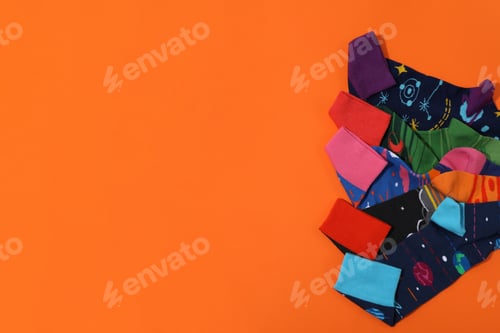 Preview: Bright socks with a print, in a pile on an orange background.