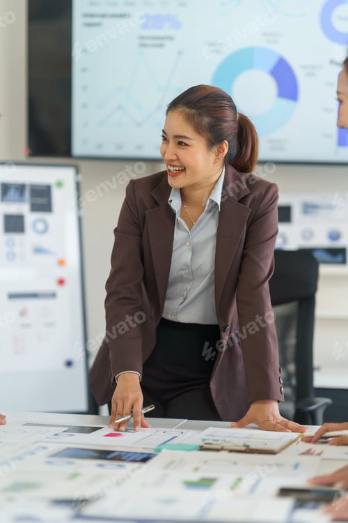Preview: Asian businesswoman pointing at charts during a meeting