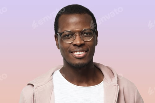 Preview: African male on purple background in pink hoodie and round glasses, looking confident and satisfied