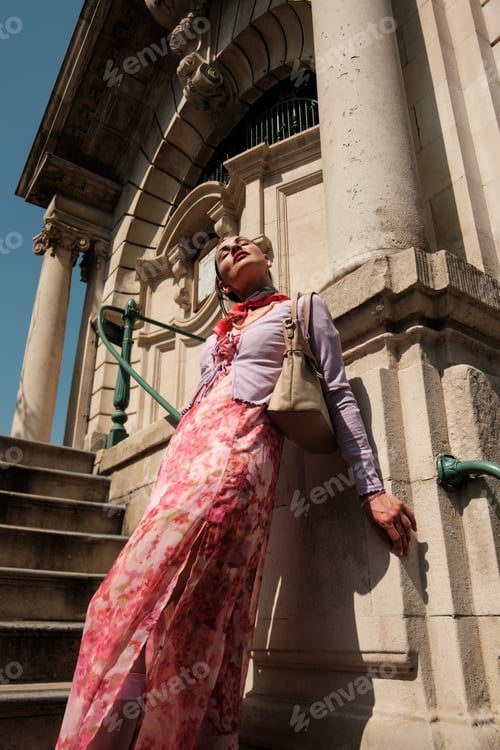 Preview: Fashion model posing near stone column of historical building