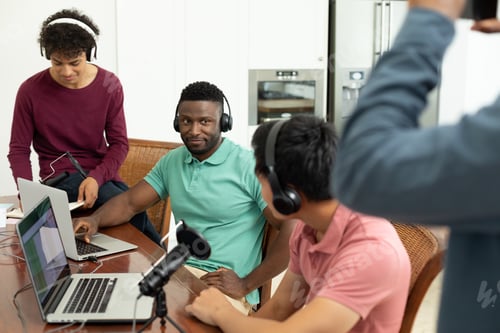 Preview: Multiracial male podcasters interviewing and recording podcast in creative office, copy space