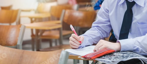 Preview: Panoramic shot of a college student writing on final examination papers in the classroom