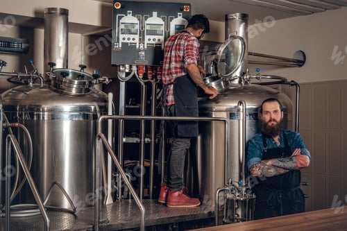 Preview: Tattooed, bearded Caucasian and Indian men in the craft beer microbrewery.