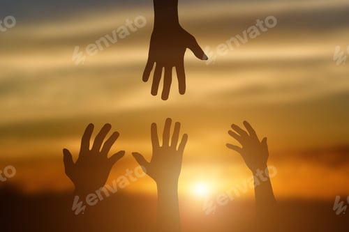 Preview: Silhouette of giving a helping hand, hope and support each other over sunset
