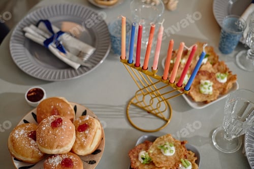 Preview: Hanukkah Menorah with Lit Candles Surrounded by Traditional Holiday Food