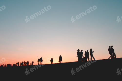 Preview: Silhouettes of people walking at sunset. People spending time outdoors on summer evening