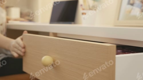 Preview: Children's room with student child. Creative. Child takes right thing from drawer and closes it