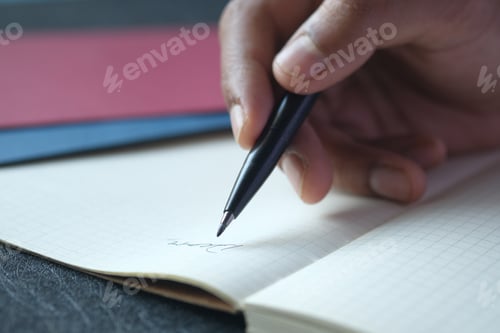 Preview: man hand writing on notepad while sited