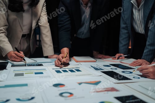Preview: Business team analyzing financial charts and graphs at night