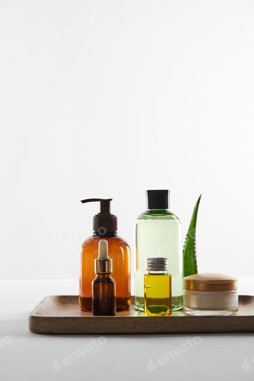 Preview: Wooden tray with various cosmetic containers and aloe vera leaf on white background