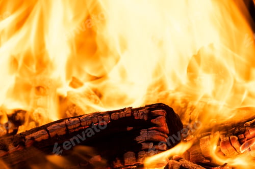 Preview: Close up of brightly burning wooden logs with yellow hot flames of fire at night
