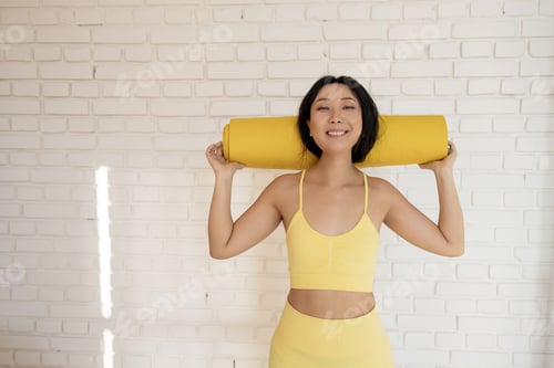 Preview: Smiling Woman Holding Yoga Mat Indoors