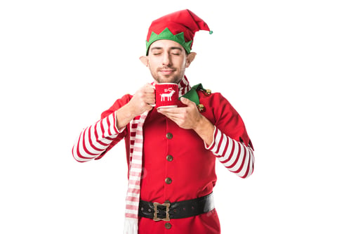 Preview: man in christmas elf costume with eyes closed holding cup of tea and inhaling aroma isolated on