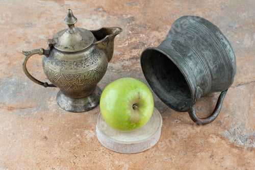 Preview: A fresh apple with an ancient cups on marble background