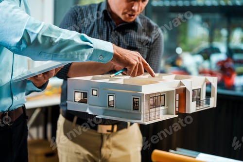 Preview: A Caucasian male engineer and an Italian male building contractor planning and talking at desk