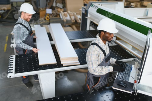 Preview: Carpenters working with wood and cnc machine in furniture factory
