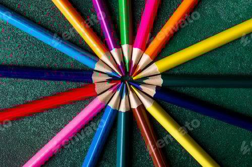 Preview: top view of colored pencils arranged on dark background