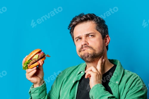 Preview: White guy in green shirt with hamburger on blue background