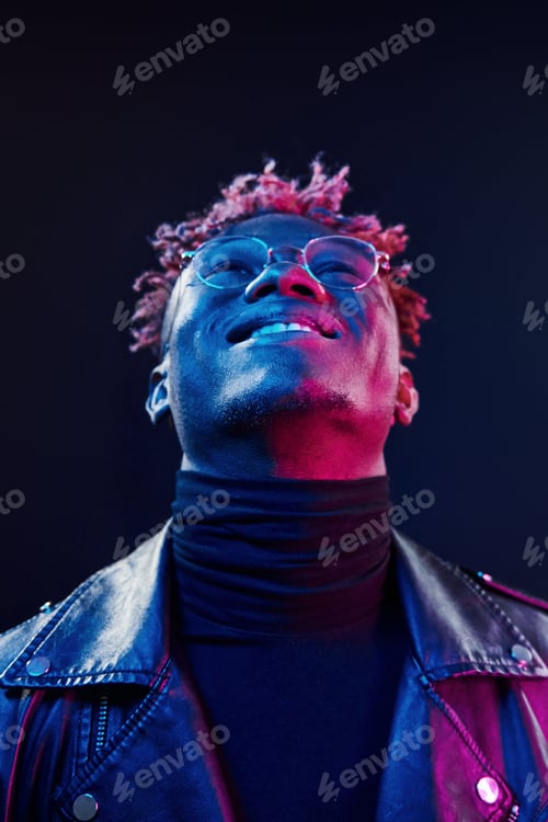 Preview: In glasses. Futuristic neon lighting. Young african american man in the studio