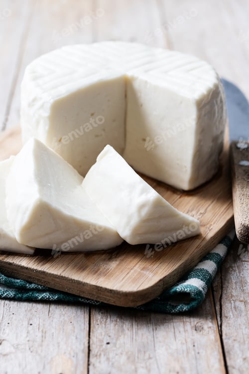 Preview: Sliced fresh white cheese from cow's milk on wooden table