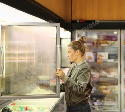 Preview: Woman Choosing Frozen Food From A Supermarket Freezer