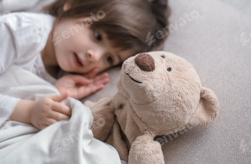 Preview: Little cute girl in bed with toy